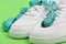 Centimeter in cyan blue color curled on white trainers