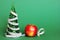 A centimeter-long ribbon is wrapped around a small green toy Christmas tree next to an Apple. The concept of healthy and healthy