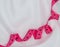 Centimeter ribbon in pink on a light white knitted fabric
