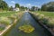 Central canal with fountains in French gardens of Villa Arnaga in Cambo-les-Bains, Two kiosks limit the gardens at background.