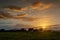 Central pivot irrigation system in a green field. Sunset over farmland in the countryside