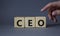 CEO - hief executive officer symbol. Concept word CEO on wooden cubes. Businessman hand. Beautiful grey background. Business and