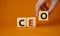 CEO - hief executive officer symbol. Concept word CEO on wooden cubes. Businessman hand. Beautiful orange background. Business and