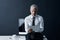 Ceo, tablet and senior man at desk in studio isolated on a dark background mockup space. Technology, reading and serious