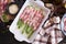 ceramic baking dish with aspargus covered with bacon on wooden kitchen table