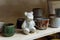 Ceramic bear and handmade dishes on the shelf of the pottery workshop.