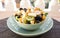 Ceramic bow full of healthy fruit salad with orange, papaya, kiwi, banana, grapes, blackberries, blueberries. Brown placemat on a