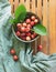 Ceramic bowl with cherries. Ripe cherries with green leaves. A bowl stands on a wooden table on a linen cloth