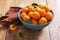 Ceramic bowl of fresh harvested apricots over wooden table