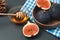 Ceramic bowl with fresh riped figs and honey on rustic black stone surface