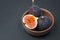 Ceramic bowl with fresh riped figs and honey on rustic black stone surface