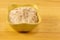 Ceramic bowl full salt large white crystal many slice on a wooden background