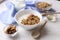 Ceramic bowl of Greek yogurt and mixed nuts. Nutritious vegetarian protein rich diet homemade breakfast with milk honey almond, ca