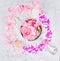 Ceramic bowl with rpnk roses and water,jars of cream,and glass bottle on gray marble table