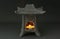 Ceramic Buddhist temple miniature with burning tea light candle.