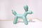 Ceramic dog doll on a white background. statuette of a dog in mint color stands on a table against a white wall in the interior of