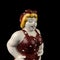 Ceramic figurine of a plump woman in a pin-up swimsuit on a black background.