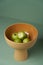 Ceramic fruit vase with apples on green background