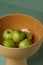 Ceramic fruit vase with apples on green background