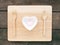 The ceramic heart shaped bowl and pink marshmallow and wooden spoon with fork on the wooden board