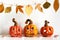 Ceramic Jack Lanterns and autumn leaves garland on table wall background. Home decoration