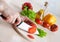 Ceramic knife in hand cutting tomatoes for salad