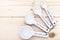 Ceramic measurement spoons on a pinewood background