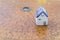 Ceramic miniature house on ancient wooden feng shui compass background