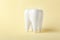 Ceramic model of tooth on color background