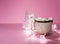 Ceramic mug with hot fresh cocoa drink and handmade funny marshmallow snowman on soft pink background