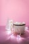 Ceramic mug with hot fresh cocoa drink and handmade funny marshmallow snowman on soft pink background