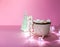 Ceramic mug with hot fresh cocoa drink and handmade funny marshmallow snowman on soft pink background