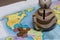 A ceramic piggy bank with a slot for coins is on the world map. Several coins are scattered nearby. Piggy bank for travel