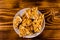 Ceramic plate with peanut brittles on wooden table. Top view