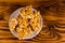 Ceramic plate with peanut brittles on wooden table. Top view