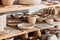 ceramic plates and bowls on wooden shelves in pottery workshop