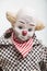 Ceramic porcelain doll of sad clown on white