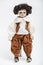 Ceramic porcelain handmade doll of a brunette boy in brown costume
