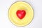 ceramic retro yellow food plate with three dimension 3d red hart symbol on top of it white background copy text space top view