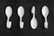 Ceramic serving spoons on black background