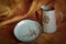 Ceramic set of dishes from a jug and a plate against the background of a piece of burlap. Pottery craft. Revival of folk tradition