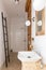 Ceramic sink on trendy wooden console table in small elegant bathroom