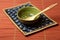 a ceramic spoon with wasabi paste on a bamboo mat