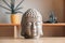 Ceramic statuette of a Buddha head on a wooden shelf. Copy, empty space for text