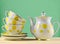 Ceramic teapot, a stack of cups in polka dots on a wooden table