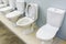 Ceramic toilet bowls in white. Plumbing trade in the store