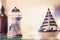 A ceramic tower decorated with seashells and a ceramic sailboat. home decoration Placed on the table under gentle lighting.