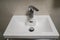 Ceramic washbasin with hot and cold faucet in luxury hotel bathroom