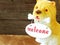 Ceramic welcome dog on wooden background