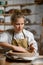 A ceramist makes a plate. Woman in an apron works in a pottery workshop.